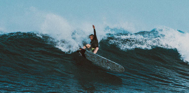 Person surfing on a wave with a clear sky