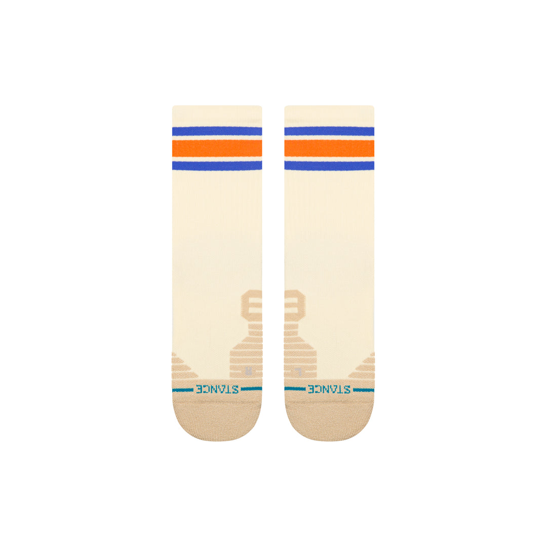 A pair of beige-coloured crew socks laid flat, with orange and blue stripes at the top and an embroidered blue STANCE logo across the toes.
