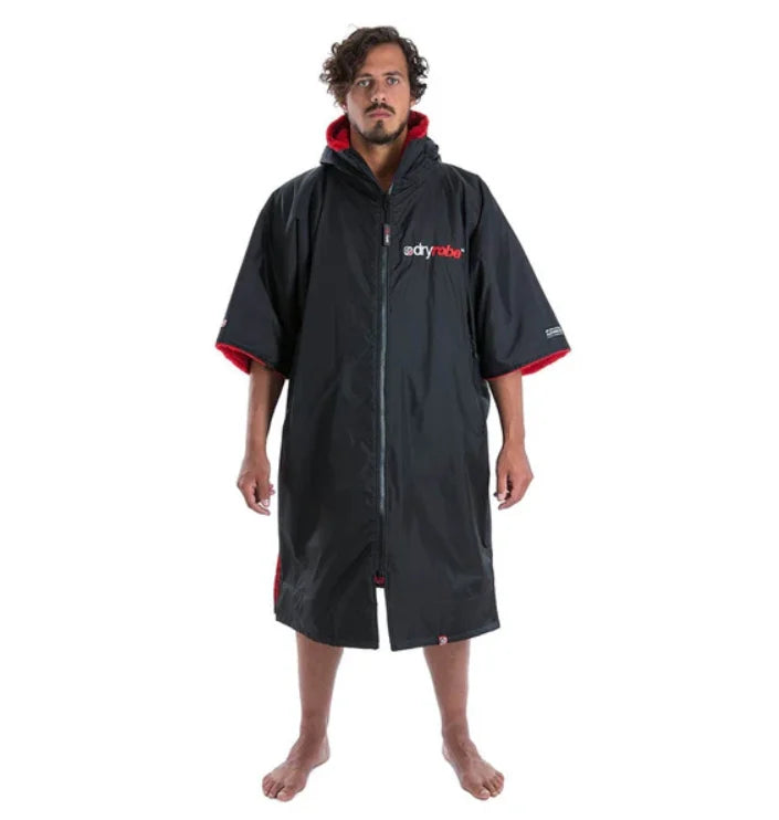 Person wearing a black Dryrobe with red accents on a white background