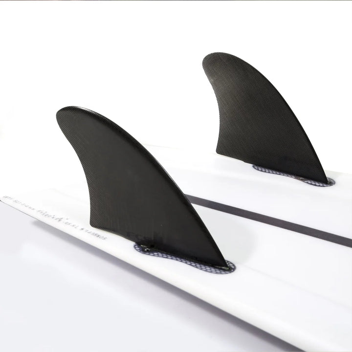 Two black surfboard fins on a white surfboard and on a white background