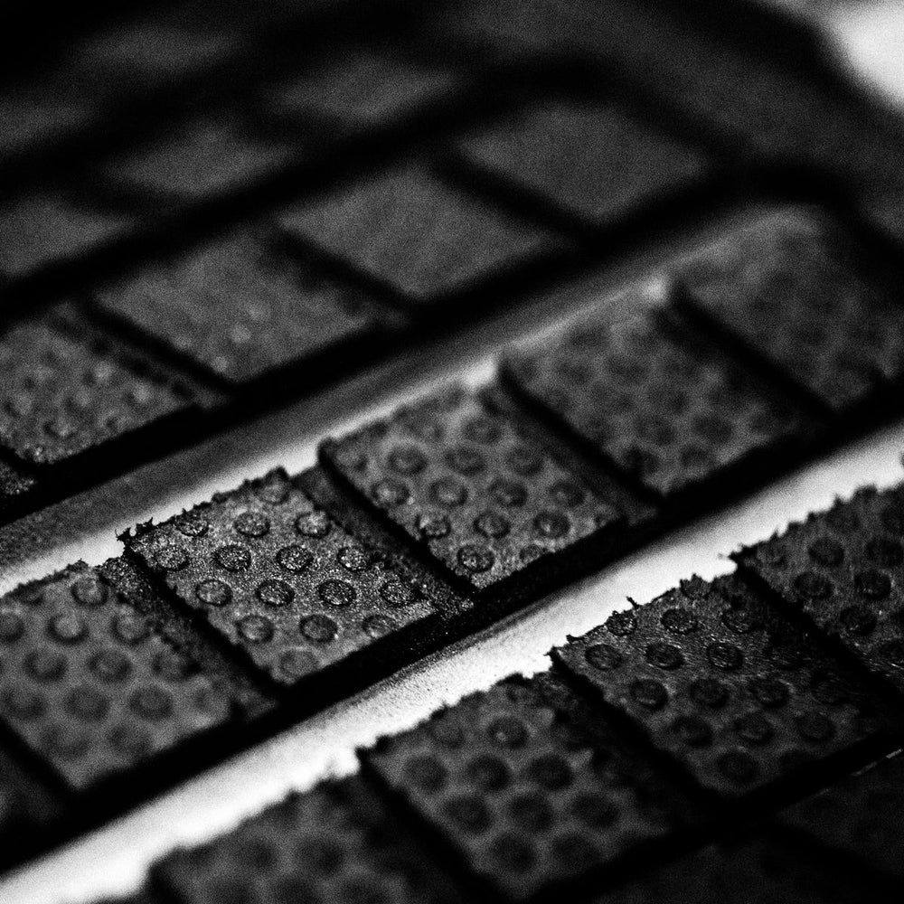 Close-up of black textured tai pad on a white surface
