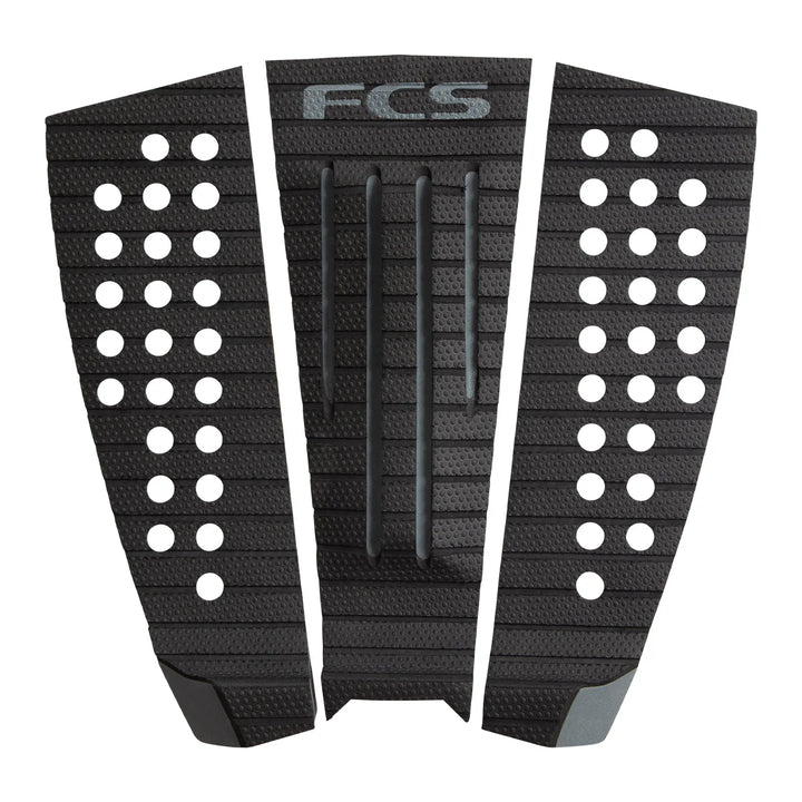 Black FCS surfboard tail pad with patterned design on a white background