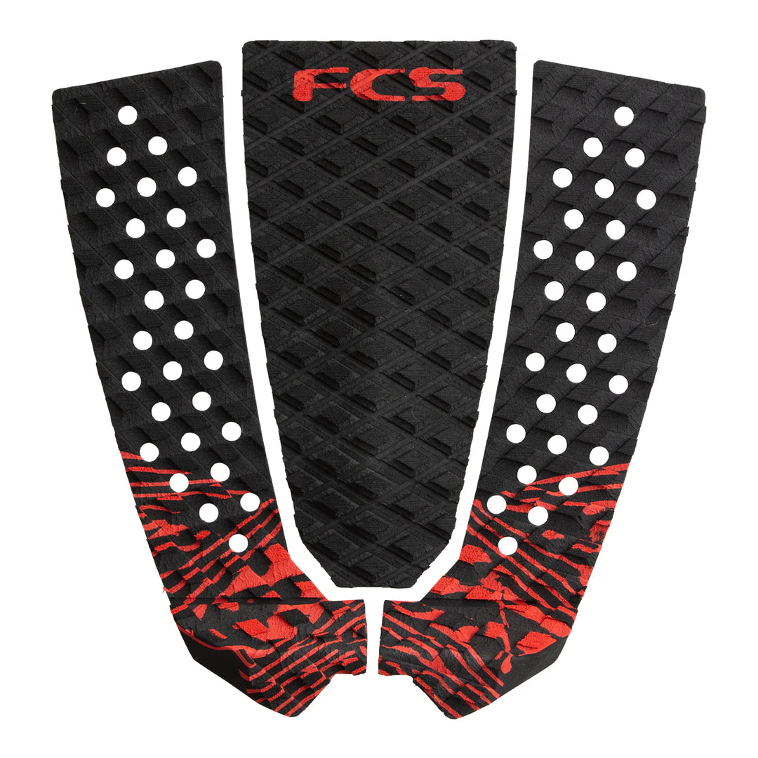 Three-piece black and red FCS surfboard tail pads on a white background