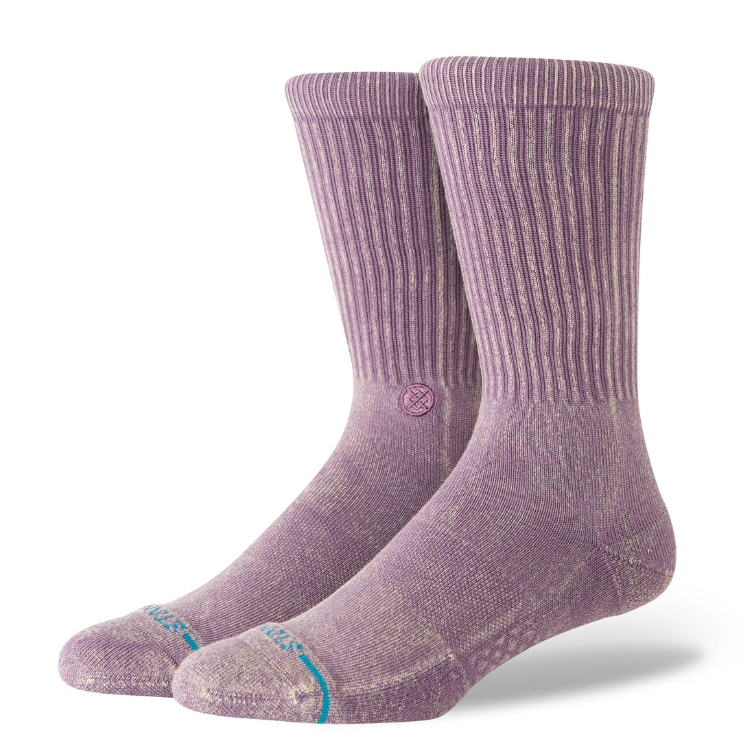 A pair of plum-coloured crew socks with a blue STANCE logo across the toes and circular icon on the inside ankle