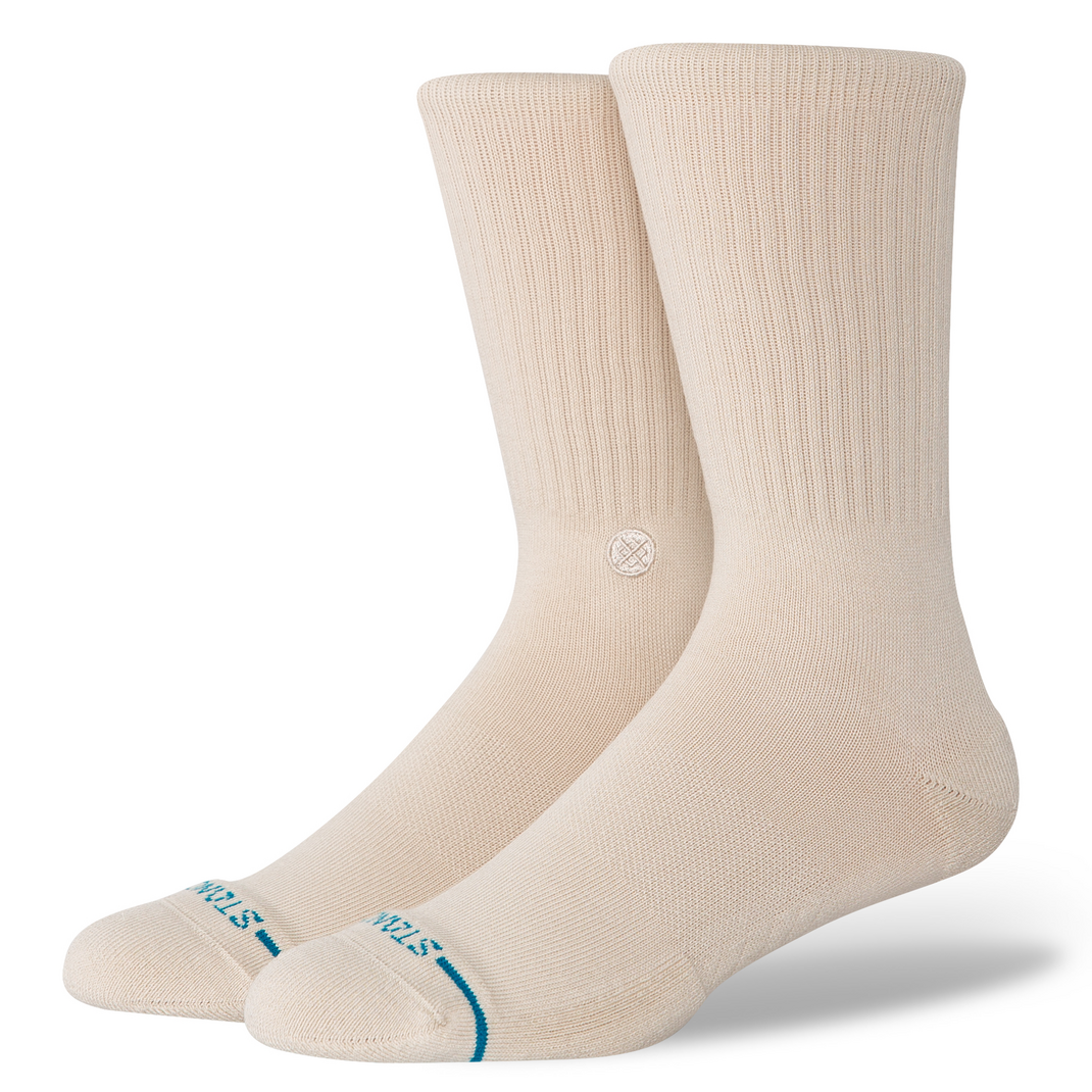 A pair of beige crew socks with a small blue &