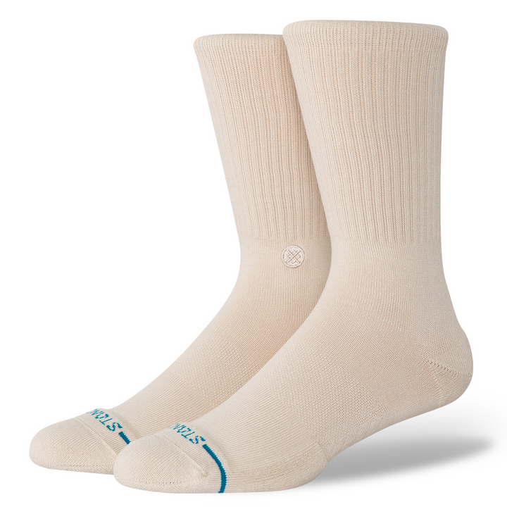 A pair of beige crew socks with a small blue &