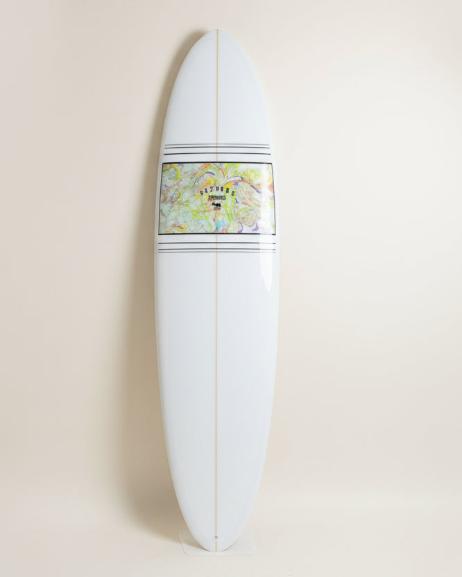 White surfboard with a colourful resin tint graphic on a cream background