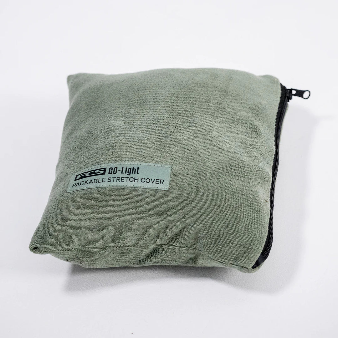 Folded green packable stretch cover with a label on a white background