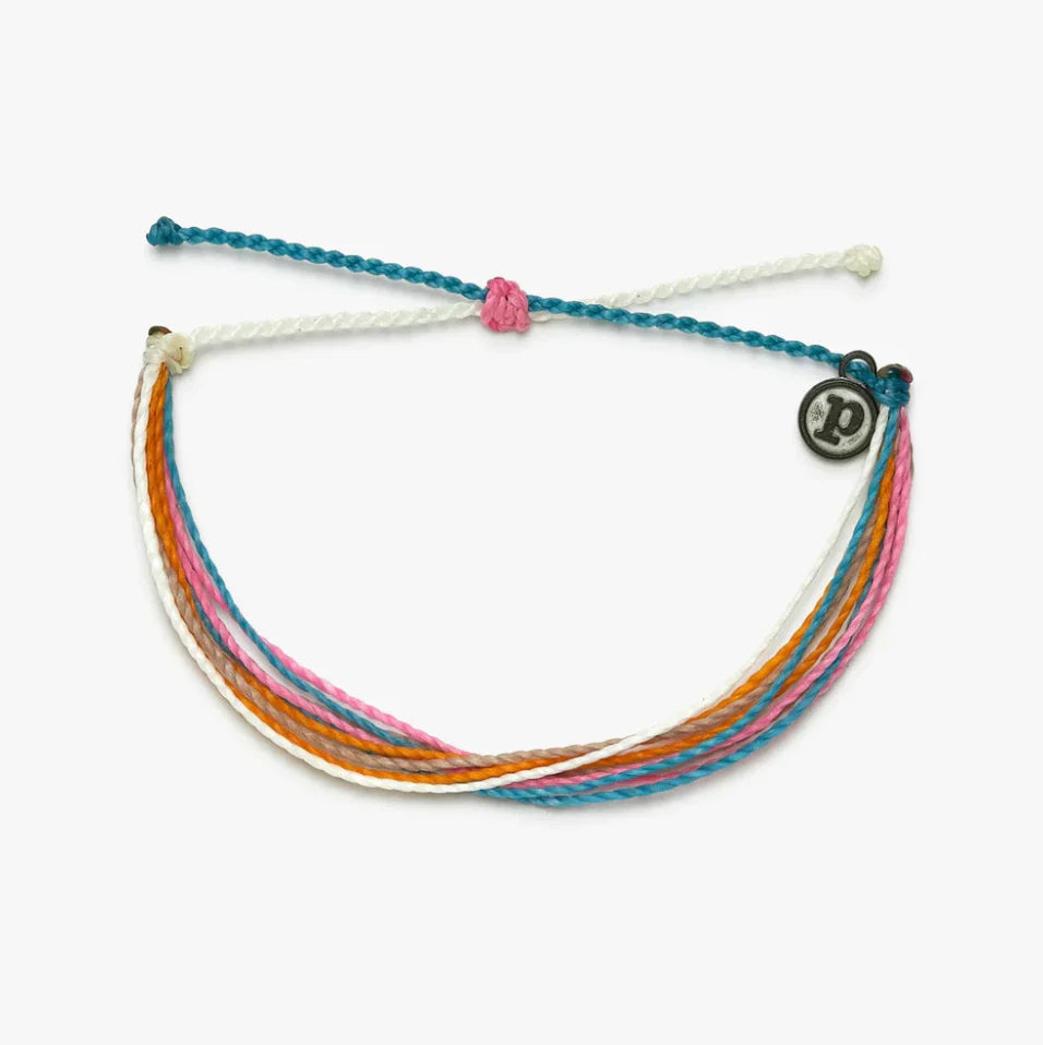 Multicolored braided bracelet with a circular charm on a white background