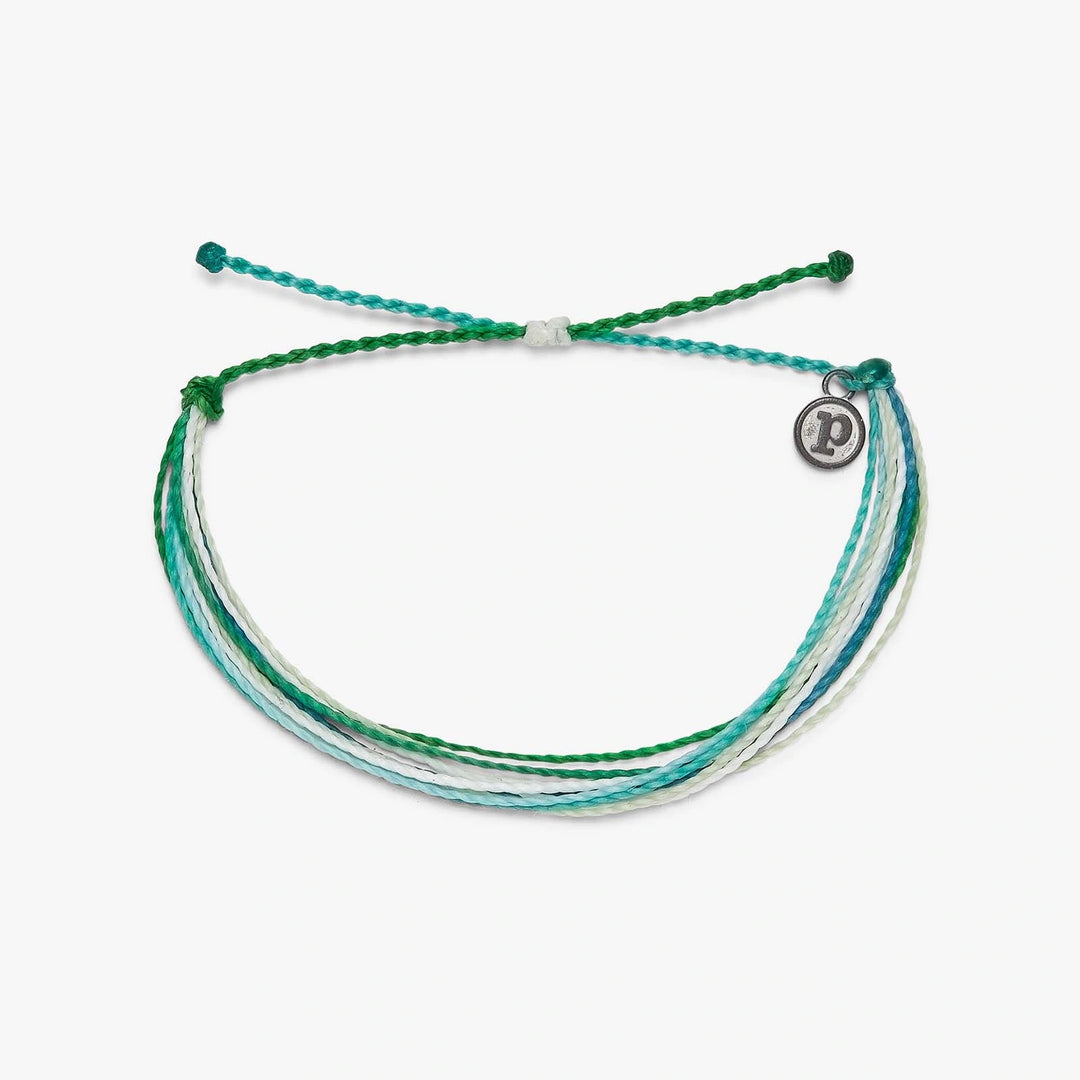 Multistrand bracelet with green and white threads on a white background