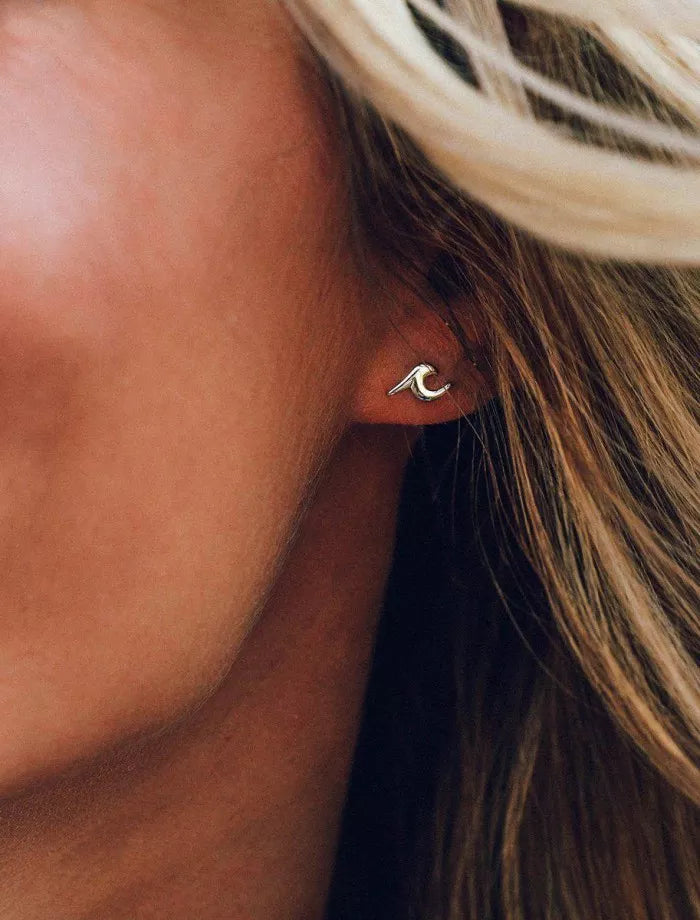 Close-up of a person wearing a wave-shaped earring.