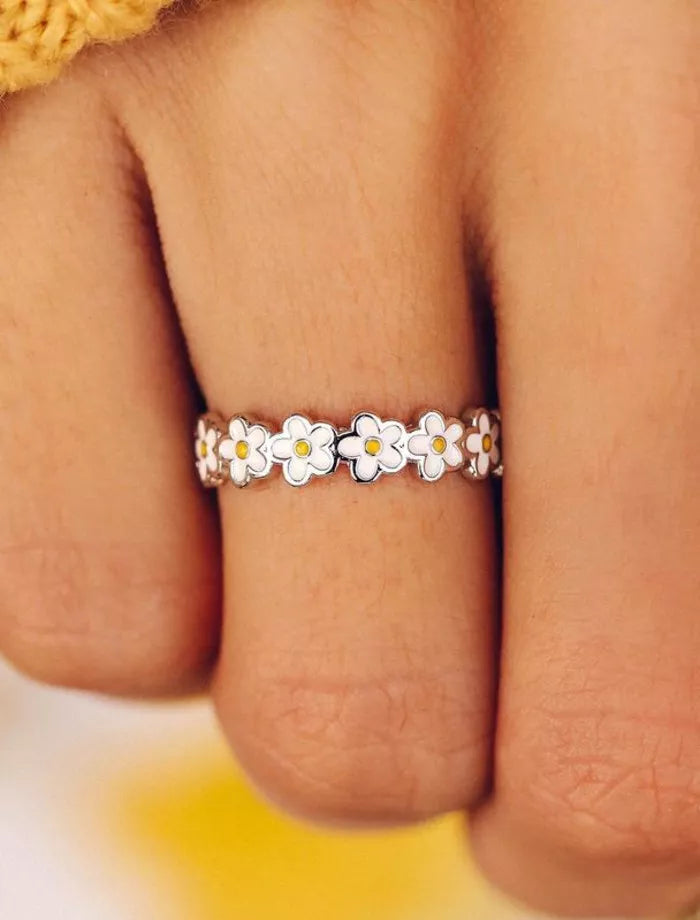 Silver ring with white daisy flowers on a person&