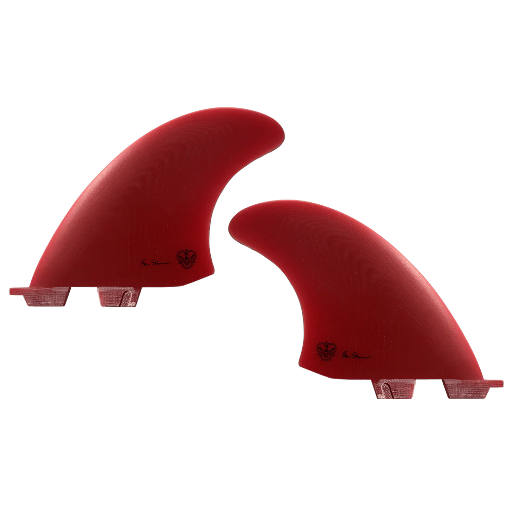 Two red surfboard fins, signed by Ben Skinner, on a white background