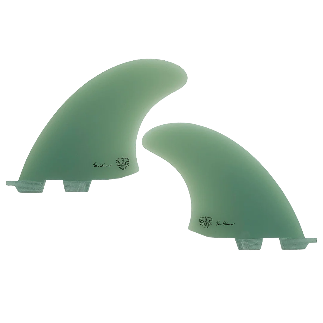 Two green surfboard fins, signed by Ben Skinner, on a white background