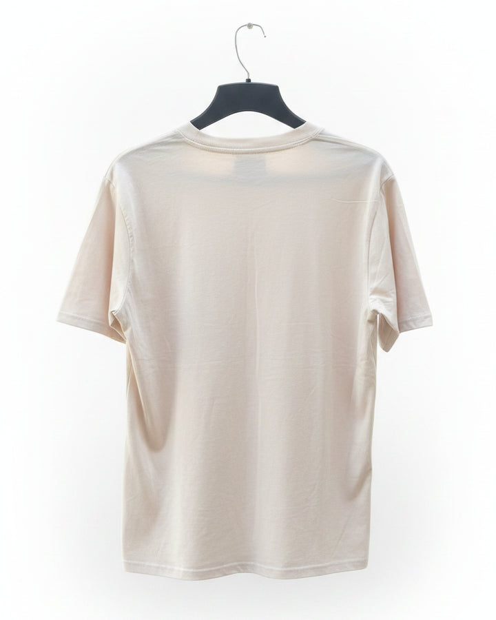 A cream-colored short-sleeve t-shirt hanging on a black hanger against a white background.