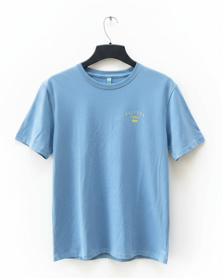A light blue crewneck t-shirt hanging on a black hanger against a white background. The shirt features a small yellow graphic on the left chest that reads &