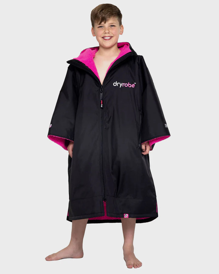 Child wearing a black and pink dryrobe on a white background