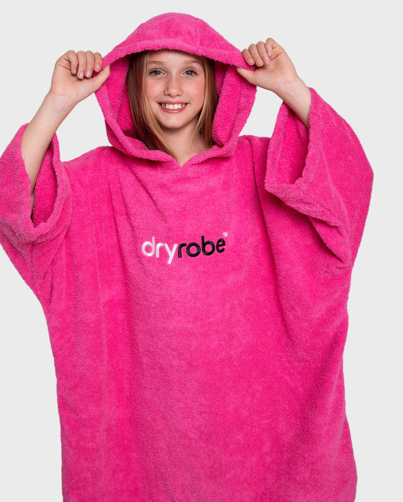 Person wearing a pink dryrobe with the brand logo on a white background